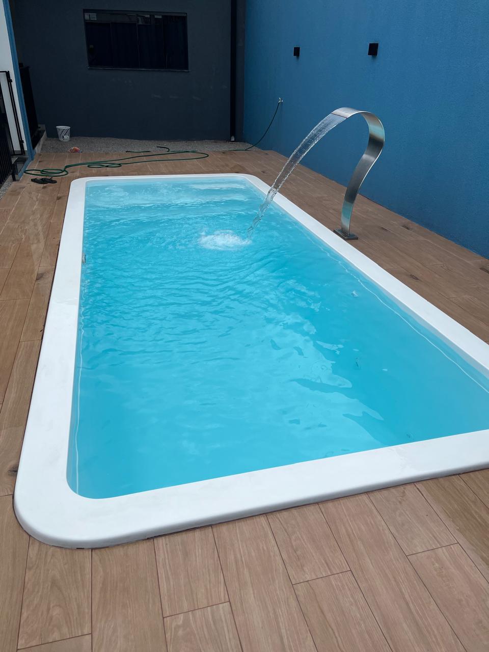 Grande piscina de fibra em jardim ensolarado para toda família